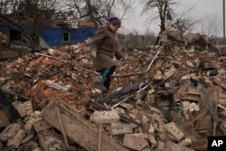 Mariya, a local resident, looks for personal items in the rubble of her house, destroyed during fighting between Russian and Ukrainian forces in the village of Yasnohorodka, on the outskirts of Kyiv, Ukraine, March 30, 2022.