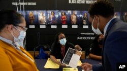 Felicia Price ( tengah) berbicara kepada Damien Walker (kanan), dan istrinya Raquel tentang peluang kerja dengan Program Head Start dan Early Head Start, selama pameran pekerjaan Miami-Dade County, Rabu, 23 Februari 2022, di pusat kota Miami. (AP/Rebecca Blackwell)