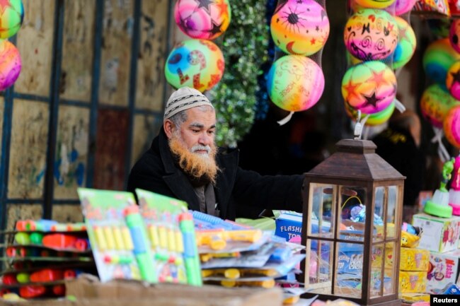 Seorang pedagang Palestina menjual mainan di pasar menjelang bulan suci Ramadhan, di Khan Younis di Jalur Gaza selatan, 30 Maret 2022. (Foto: REUTERS/Ibraheem Abu Mustafa)