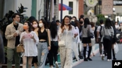 FILE - People wearing face masks to protect against the spread of the coronavirus go shopping in Taipei, Taiwan, Nov. 21, 2021.