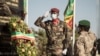 Le président malien de transition, le colonel Assimi Goïta (à droite) regarde après avoir déposé une gerbe sur le monument aux morts, lors de la cérémonie célébrant la fête nationale de l'armée, à Kati, le 20 janvier 2022. (Photo par FLORENT VERGNES / AFP ) 