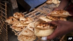 FILE - A worker collects Egyptian traditional baladi flatbread, at a bakery in el-Sharabia, Shubra district, Cairo, Egypt, March 2, 2022. The war has raised the specter of food shortages and political instability in countries that rely on affordable grain imports like Egypt.