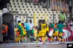 Ghana's soccer players run off the pitch after it was invaded at the end of their 2022 Qatar World Cup qualifying playoff win at Moshood Abiola National Stadium, in Abuja, Nigeria, March. 29, 2022.