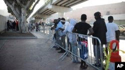 FILE - Migrants from Africa, Central America and Haiti wait to see if their number will be called to cross the border and apply for asylum in the United States, at the El Chaparral border crossing in Tijuana, Mexico, Sept. 13, 2019.