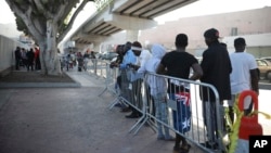 FILE - Migrants from Africa, Central America and Haiti wait to see if their numbers will be called to cross the border and apply for asylum in the United States, at the El Chaparral border crossing in Tijuana, Mexico, Sept. 13, 2019.