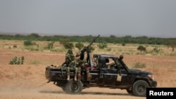 FILE - Niger's army soldiers ride on a pickup truck near Agadez, Niger, Oct. 29, 2019.