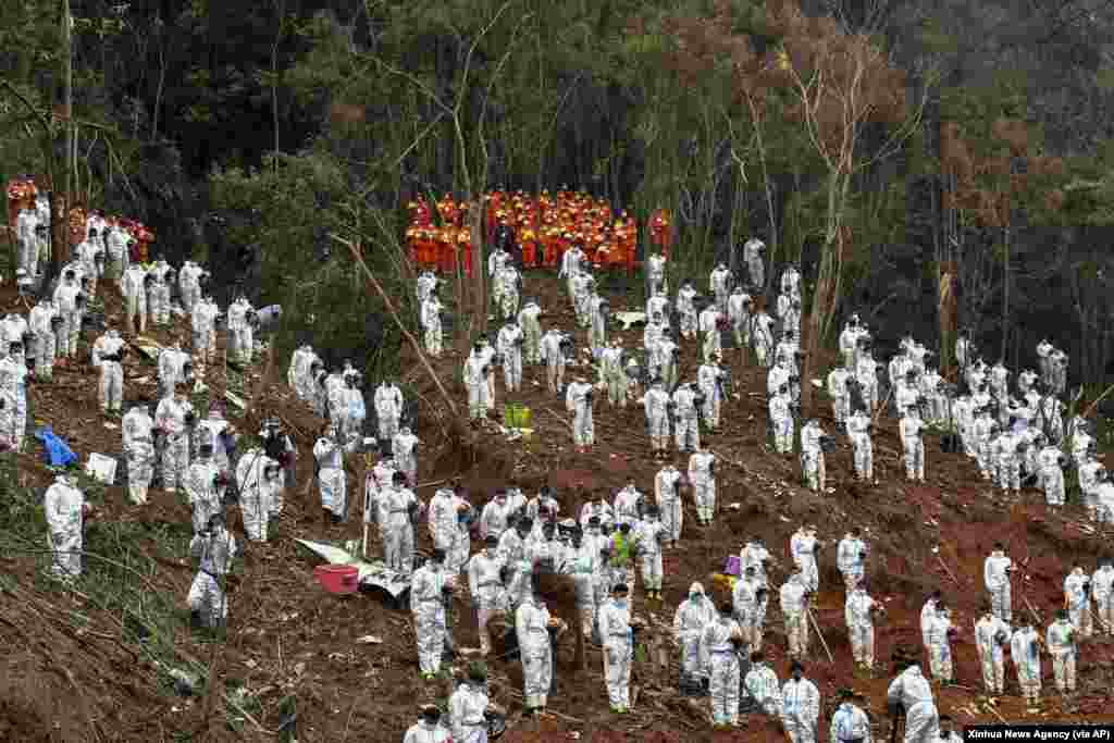 Search and rescue workers pause for a three-minute moment of silence for the 132 people killed at the China Eastern flight crash site in Tengxian County in southern China&#39;s Guangxi Zhuang Autonomous Region. The second &quot;black box&quot; from a China Eastern Boeing 737-800 was found, raising hopes that it might shed light on why the passenger plane nosedived into a remote mountainous area last week.