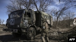 Ukranian troops drive a captured Russian military vehicle after retaken the village of Mala Rogan, East of Kharkiv, on March 28, 2022