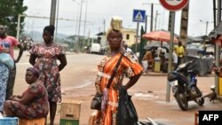 FILE - Street vendors are seen in Noe, a border town between Ivory Coast and Ghana where residents have not been able to cross due to the COVID-19 pandemic, Sept. 22, 2021. 