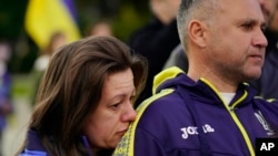 Natalia Kurkchy leans her head on the shoulder of her husband, Peter, during a protest of the Russian invasion of Ukraine held in Sacramento, Calif., Feb. 24, 2022. The Kurkchy's immigrated in 2015 and are concerned for family members in Ukraine.