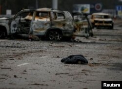 Thi thể một thường dân, theo lời người dân nói là bị lính Nga giết chết, nằm gần những chiếc xe hơi bị cháy trên đường cao tốc, tại làng Myla, vùng Kyiv, Ukraine, ngày 2 tháng 4 năm 2022.