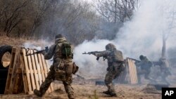 Tentara Ukraina menembakkan senjata mereka, selama latihan di sebuah lokasi yang dirahasiakan, dekat Lviv, Ukraina barat, 29 Maret 2022. (Foto: AP)