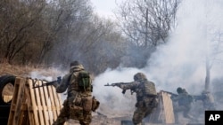 Soldados ucranianos disparan sus armas durante un ejercicio de entrenamiento en un lugar no revelado, cerca de Lviv, en el oeste de Ucrania, el 29 de marzo de 2022.