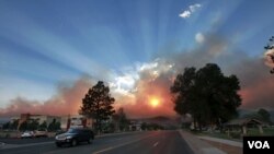 Cahaya matahari terbit tertutup oleh asap kebakaran hutan di di Las Conchas , New Mexico, (29/6).