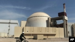 ARCHIVO – Un trabajador conduce una bicicleta frente al reactor de la planta nuclear de las afueras de la ciudad de Bushehr, en el sur de Irán, el 26 de octubre de 2010. 