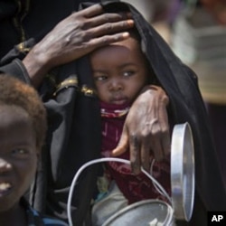 A mother with her child seeking food aid in Mogadishu last month. The United Nations has now declared the end of the famine in Somalia, February 3, 2012