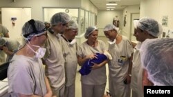 Medical team hold the first baby born via uterus transplant from a deceased donor at the hospital in Sao Paulo, Brazil, Dec. 15, 2017, in this picture handout obtained Dec. 4, 2018. 