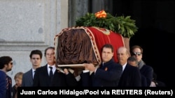 Родичі покійного іспанського диктатора Франсіско Франко несуть домовину з його останками після ексгумації з мавзолею в Долині полеглих 24 жовтня 2019 р.