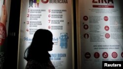  A woman stands near a poster explaining the Zika virus at the Ministry of Health office in Jakarta, Indonesia, Sept. 2, 2016. 