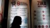 FILE - A woman stands near a poster explaining the Zika virus at the Ministry of Health office in Jakarta, Indonesia, Sept. 2, 2016. 