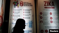 FILE - A woman stands near a poster explaining the Zika virus at the Ministry of Health office in Jakarta, Indonesia, Sept. 2, 2016. 