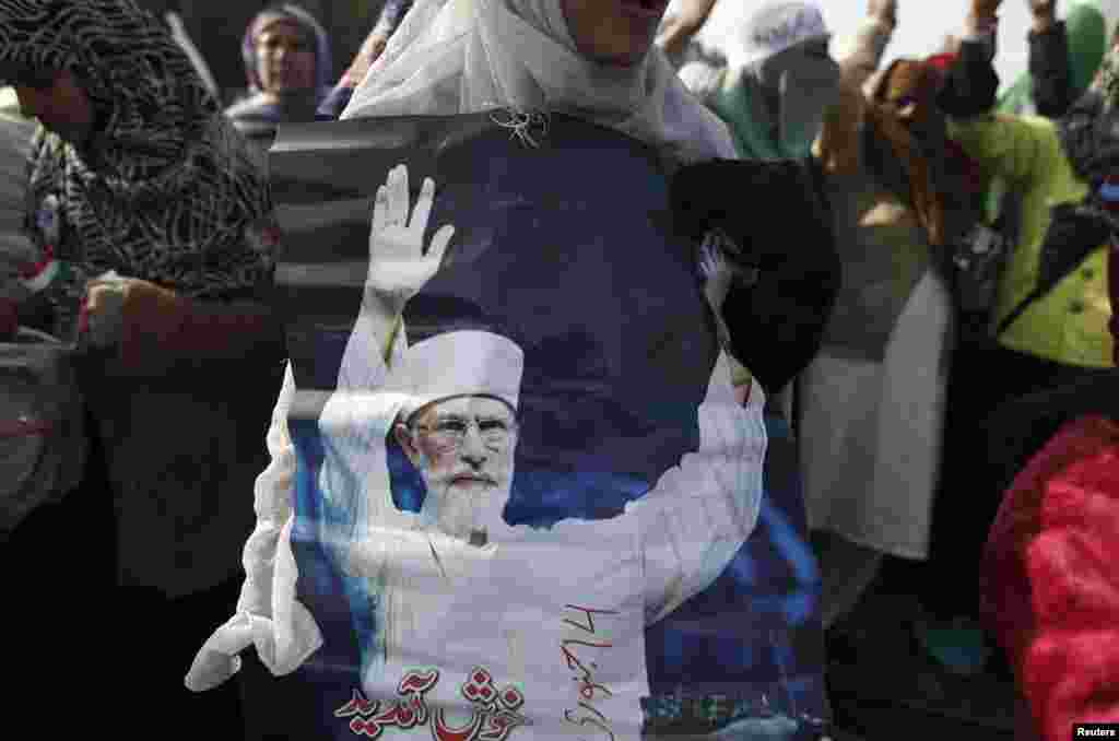 A woman holds a photograph of Tahirul Qadri during a protest in Islamabad, Pakistan, January 14, 2013. 