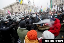 Ukrainian law enforcement officers use tear gas as they block demonstrators during a rally of entrepreneurs and representatives of small businesses amid the coronavirus disease (COVID-19) outbreak in Kyiv, Ukraine, December 15, 2020.