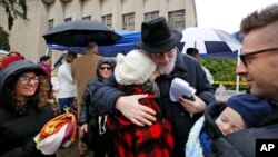 Rabbi Chuck Diamond, center, a former rabbi at the Tree of Life synagogue, hugs a woman after leading a Shabbat service outside Tree of Life, Nov. 3, 2018, in Pittsburgh. On Oct. 27, 11 people were killed and six wounded when a gunman attacked them in the synagogue. 