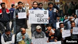 Uber taxi drivers hold placards during a protest against the ban on online taxi services, in New Delhi, Dec. 12, 2014. (REUTERS/Anindito Mukherjee)