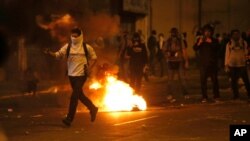 Seorang demonstran menantang barisan Pasukan Nasional Bolivaria dalam aksi protes anti-pemerintah di Caracas, Venezuela (28/2).