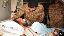 Pakistan's Lt. Gen. Zafar Iqbal Malik enquires about the health of a Kashmiri villager injured by Indian firing, during a hospital visit in Muzaffarabad, Pakistan, Nov. 24, 2016. Pakistan's air force chief has warned arch-rival India against escalating the dispute over Kashmir into full-scale war. 