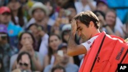 Petenis Swiss, Roger Federer, meninggalkan lapangan setelah kalah dari petenis Afrika Selatan, Kevin Anderson, dalam perempat final tunggal putra turnamen tenis Wimbledon, di London, Rabu, 11 Juli 2018.