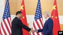 امریکہ کے صدر جو بائیڈن اور ان کے چینی ہم منصب شی جن پنگ انڈونیشیا میں ملاقات کے آغازپر مصافحہ کر رہے ہیں۔ فوٹو: اے پی 