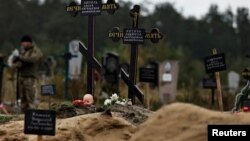 Могили двох дітей у місці масового поховання в нещодавно звільненому від російської окупації Лимані, Донеччина, 11 жовтня 2022. REUTERS/Zohra Bensemra