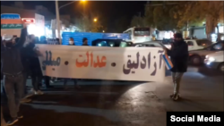 In a UGC photo posted on social media Nov. 2, 2022, protesters in Tabriz, northwestern Iran, unfurl a banner reading "Freedom, justice, national government."