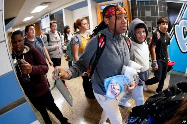 Students at the Washington Junior High School leaving classes for the day, use the unlocking mechanism to open the bags their cell phone were sealed in during the school day, Thursday, Oct. 27, 2022. (AP Photo/Keith Srakocic)