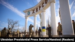 Ukraine's President Volodymyr Zelenskyy awards a serviceman as he visits Kherson, Nov. 14, 2022.