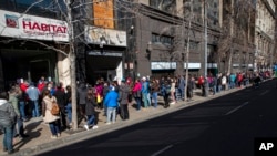 En esta foto de archivo del 17 de agosto de 2020, personas esperan afuera de la oficina de administración de pensiones, en el centro de Santiago de Chile.