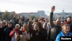 Local residents react during a visit of Ukraine's President Volodymyr Zelenskiy after Russia's retreat from Kherson, in central Kherson, Nov. 14, 2022.