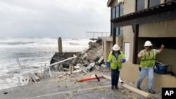 Workers check on Pirates Cove Condos in Daytona Beach Shores, Florida, on Nov. 10, 2022, after part of the building collapsed due to a storm surge by Hurricane Nicole .