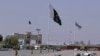 FILE - Pakistan and Taliban flags are seen on their respective sides near Friendship gate at a border crossing point in Chaman, Pakistan, Aug. 27, 2021.