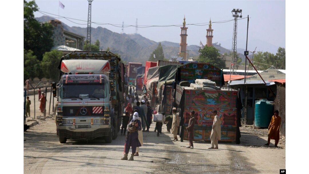 Seorang anggota Taliban berjaga di samping truk yang menunggu untuk menyeberang di titik penyeberangan perbatasan antara Pakistan dan Afghanistan, di Torkham, di distrik Khyber, Pakistan, 21 Agustus 2021. (Foto: AP)