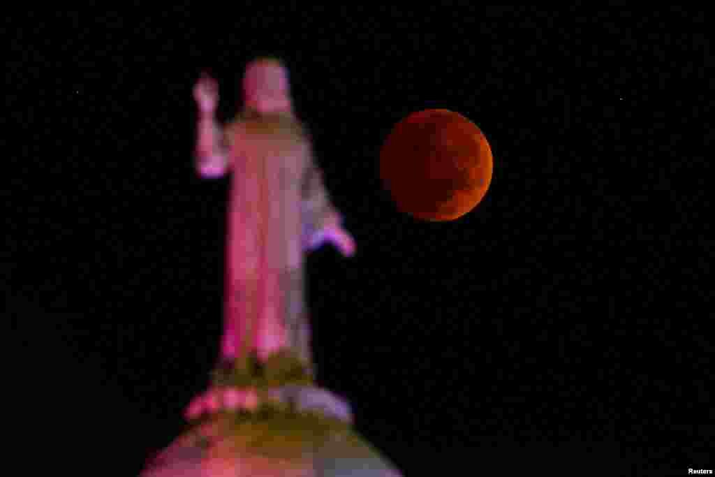 The moon and a statue are seen during a lunar eclipse in San Salvador, El Salvador, November 8, 2022.&nbsp;