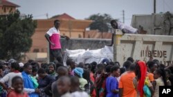 People await a food distribution from a truck aimed to help those affected by the travel restrictions imposed in an attempt to limit the spread of Ebola, in Mubende, Uganda on Nov. 1, 2022. Ugandan health officials said Friday the cases are gradually stabilizing.