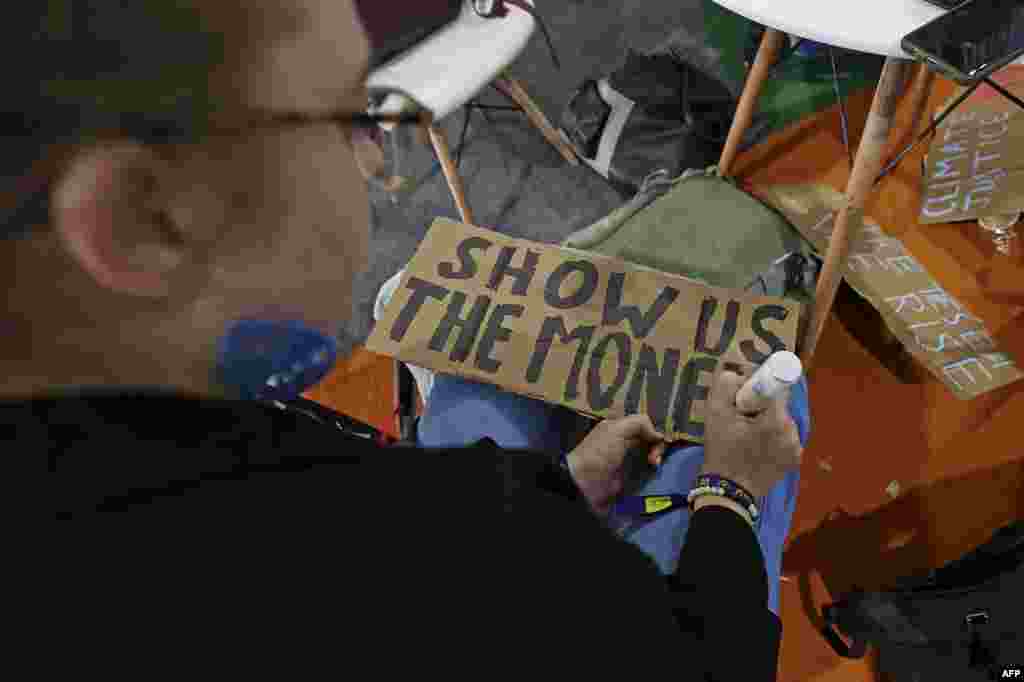 Climate activists prepare placards for a protest during the COP27 climate conference in the Red Sea resort of Sharm el-Sheikh, on November 11, 2022.