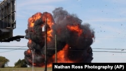 This photo provided by Nathaniel Ross Photography, a historic military plane crashes after colliding with another plane during an airshow at Dallas Executive Airport in Dallas on Saturday, Nov. 12, 2022. (Nathaniel Ross Photography via AP)