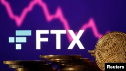 FILE: Representations of cryptocurrencies are seen in front of displayed FTX logo and decreasing stock graph in this illustration taken Nov.10, 2022