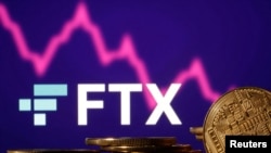 FILE PHOTO: Representations of cryptocurrencies are seen in front of displayed FTX logo and decreasing stock graph in this illustration taken Nov.10, 2022