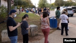 Austin Guajardo, left, and his mother, Nelda Guajardo, wait in an hour-long line at the Dittmar Recreation Center during the U.S. midterm elections in Austin, Texas, Nov. 8, 2022.