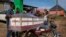 People load a coffin onto the back of a motorcycle to transport it for the burial of an Ebola victim, in the town of Kassanda, Uganda, Nov. 1, 2022.